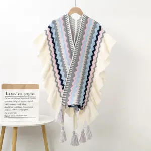 Detailed view of the ethnic knitted poncho with colorful wavy stripes, ruffles, and tassels.