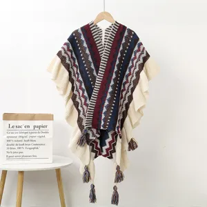 Ethnic style knitted long cape with geometric patterns, ruffled edges, and tassel details.