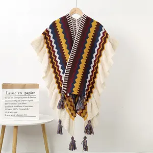 Ethnic style knitted shawl with geometric waves, ruffles and tassels for warm winter wear.