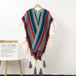 Detailed view of the colorful geometric knitted poncho with ruffles and cute tassels.