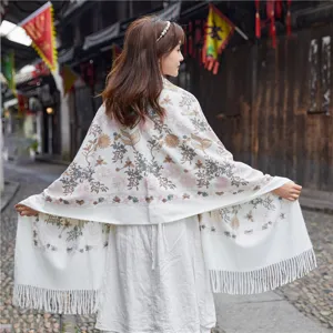 Detailed view of the autumn winter floral embroidered cashmere feel tassel shawl in scenic background.