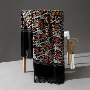 Detailed view of the black cashmere-feel embroidered paisley ethnic style scarf with delicate fringe.