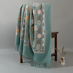 Close up detail of the teal embroidered cashmere feel shawl with exquisite floral motifs.