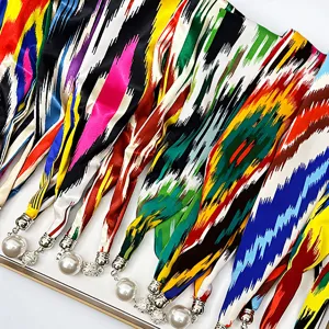 Vibrant multi-color ikat stripe silk scarves featuring elegant magnetic pearl pendant closures.