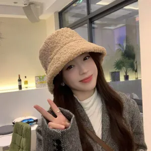 Detailed view of winter beige lambswool bucket hat worn by model, cozy fleece fabric style.