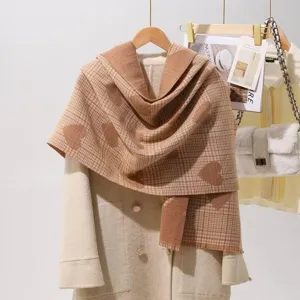 Close-up of cozy plaid faux cashmere scarf with heart pattern, soft texture detail.