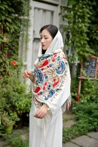 Detail view of women ethnic style embroidered paisley shawl scarf with warm tassels.