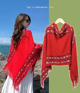 Detailed view of the vintage ethnic knit shawl with tassel trim and geometric pattern scene.