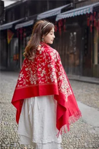 Detail shot of women's red floral embroidered tassel imitation cashmere shawl for winter fashion.