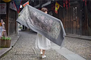 Detailed view of women's ethnic style imitation cashmere scarf with exquisite floral embroidery and tassel.