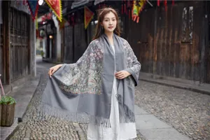 Detailed view of grey cashmere-feel shawl with ethnic embroidery and elegant fringe.