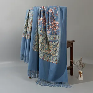 Detailed view of blue ethnic style embroidered imitation cashmere shawl with tassels.