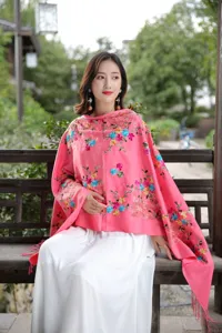 Detailed view of the vibrant pink cashmere shawl featuring exquisite colorful floral embroidery.