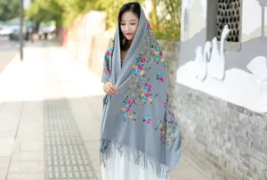 Ethnic style embroidered cashmere shawl, cozy winter scarf with fringe and floral details.