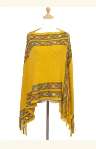 Detailed close-up view of the vintage ethnic style yellow knitted poncho with elegant tassels.