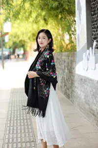 Close-up view of the exquisite multi-color floral embroidery details on the black shawl.