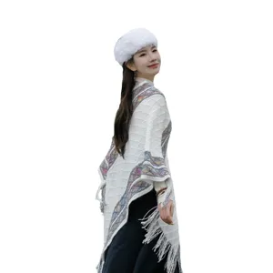 Boho fringe knit poncho cape for women, warm winter knitted shawl outerwear, stylish travel apparel.