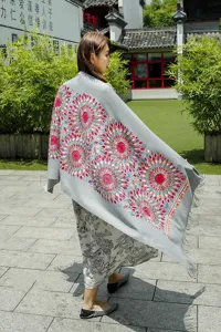 Ethnic style embroidered cashmere-feel shawl detail featuring vibrant sunflower pattern and fringe.