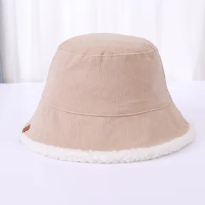 Detail view of the beige corduroy and sherpa bucket hat, showing texture and small letter tag.