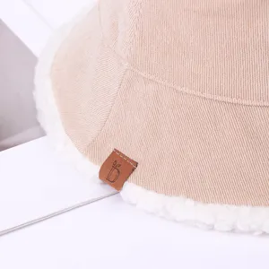 Winter corduroy bucket hat for women, thick warm lamb wool lining, stylish brown leather tag.
