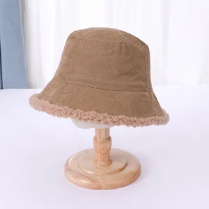 Detailed shot of brown corduroy bucket hat featuring cozy lamb wool trim for cold days.