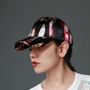 Detailed shot of ethnic print baseball cap, colorful ikat pattern on black silk-like fabric.