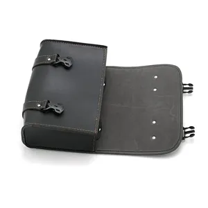 Nahaufnahme Detail der schwarzen Leder Motorrad Satteltasche mit braunen Naehten und Klickschnallen.