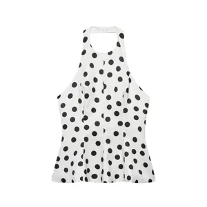 Top licou chic à pois noirs et blancs avec bas de jupe évasé pour un look estival élégant.
