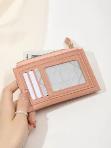 Pink minimalist cardholder wallet detail showing multiple slots and zipper coin pocket.