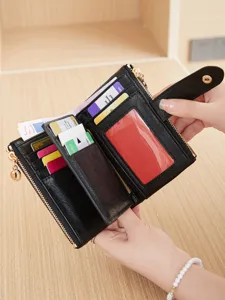 Detail view of a black women's short wallet with double zippers, multiple card slots, and snap closure.