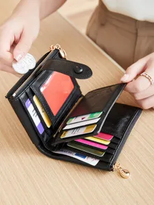 Detail view of black women tri-fold wallet showing card slots and coin pocket design.