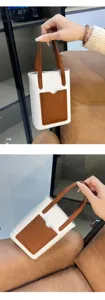 Detailed view of the minimalist color-block handbag showing lychee pattern texture and pocket.