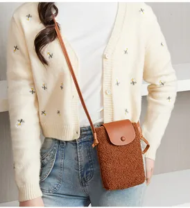Close up detail of brown plush crossbody phone bag with leather flap, casual daily accessory.