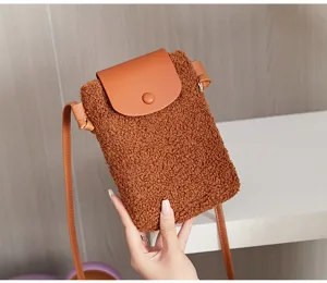 Detailed view of the brown plush phone bag, showing fuzzy texture and leather flap design.