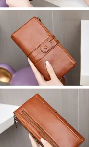 Close-up view of the brown leather long wallet featuring double zippers and card slots.
