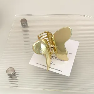 Molletta per capelli a farfalla in metallo dorato dettaglio, accessorio elegante.