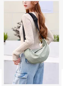Lightweight nylon dumpling crossbody bag worn by model, showing side profile and fabric detail.