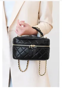 Close-up detail of the black quilted leather vanity bag with elegant golden chain strap.