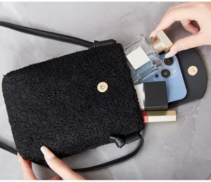 Detail view of black plush phone crossbody bag with capacity for daily essentials and phone.