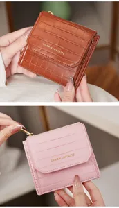Gros plan détaillé d'un portefeuille court pour femme avec motif croco chic et fermeture à pression.