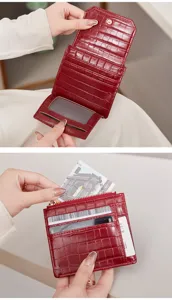 Portefeuille court à trois volets effet croco rouge avec emplacements pour cartes et poche zippée.