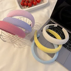 Vue détaillée des serre-têtes larges et colorés en tissu texturé pour les femmes.