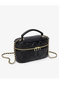 Detail view of black quilted leather vanity shoulder bag with gold chain and handle.