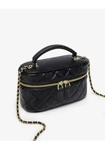 Close-up view of the black quilted vanity bag showing detailed gold hardware and fine texture.