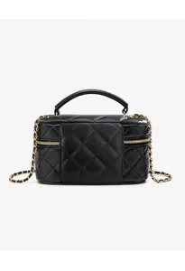 Black quilted leather vanity bag detail with gold chain handle and zipper closure.