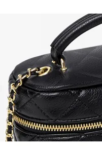 Black quilted leather vanity bag detail showing gold chain strap and zipper hardware.