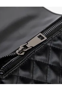 Close-up detail of black quilted leather crossbody bag with metal zipper and fine stitching.