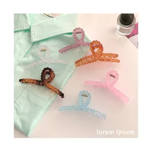 Vue detaillee de pinces a cheveux en perles matifiees de diverses couleurs sur une chemise.