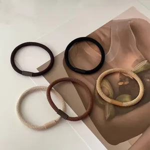 Detailed shot of basic twill hair ties in neutral earth tones, minimalist design.