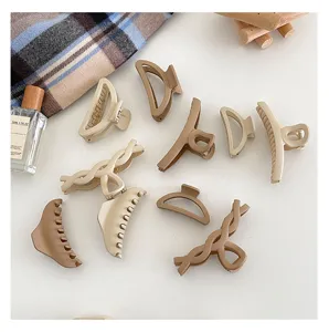 Close-up detail of assorted neutral minimalist hair claws, stylish matte finish hair accessories.